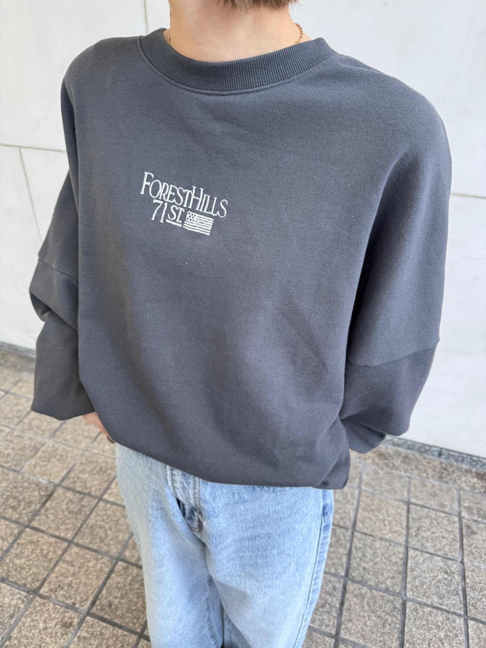 グレー系のスウェット、ブルー系のデニムパンツ、グレー系のニットキャップ/ビーニーを着用したレディースの冬コーディネートの8枚目の写真