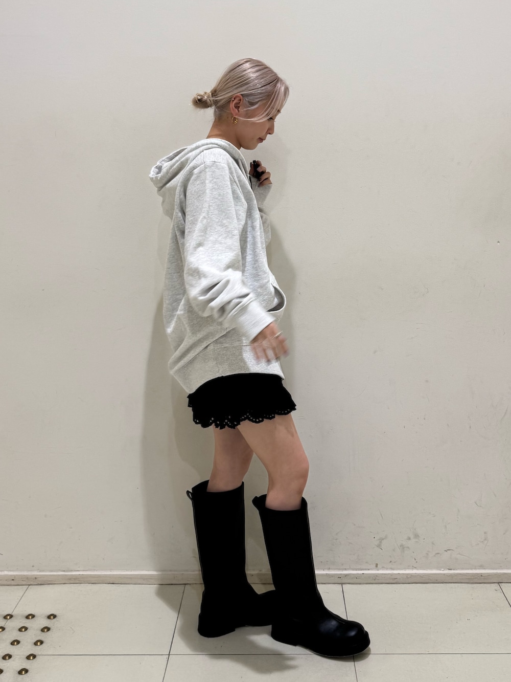 グレー系のパーカー、ブラック系のその他パンツ、ブラック系のブーツを着用したレディースの春コーディネートの2枚目の写真