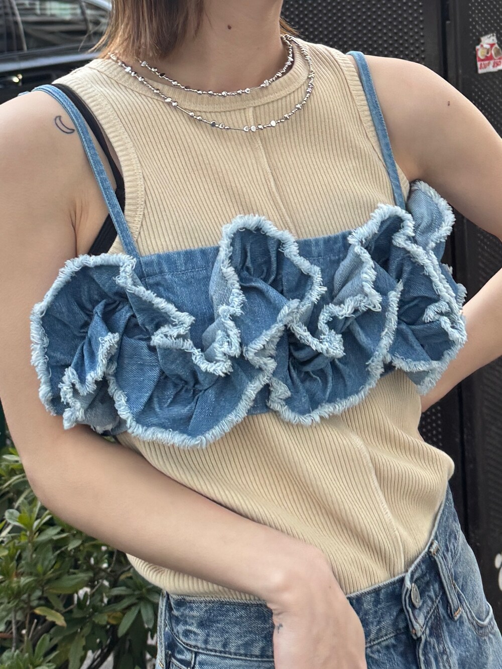 ブルー系のキャミソール、ホワイト系のタンクトップ、ブルー系のデニムパンツを着用したレディースの春コーディネートの5枚目の写真