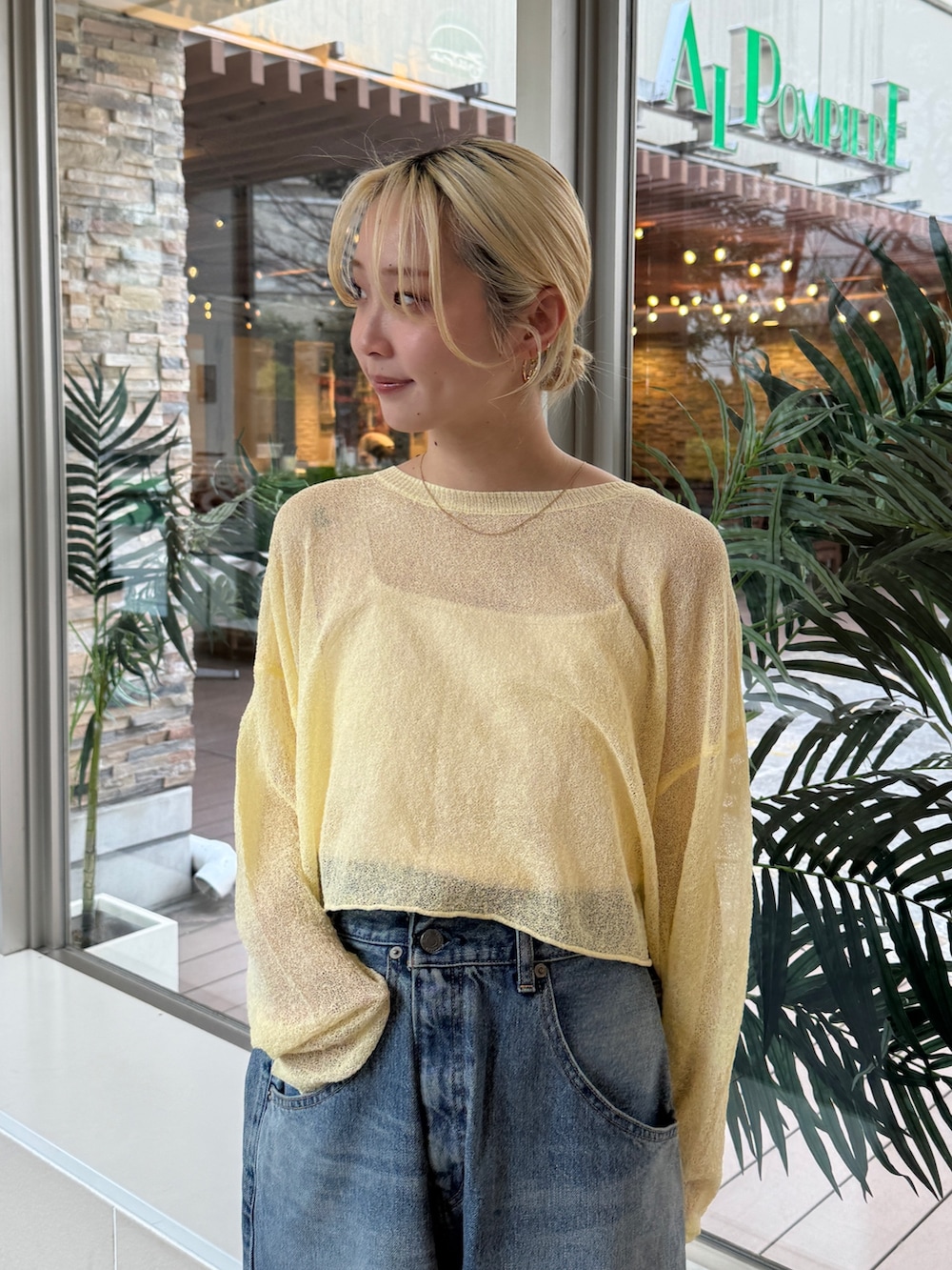 イエロー系のニット/セーター、ブルー系のデニムパンツを着用したレディースの冬コーディネートの4枚目の写真