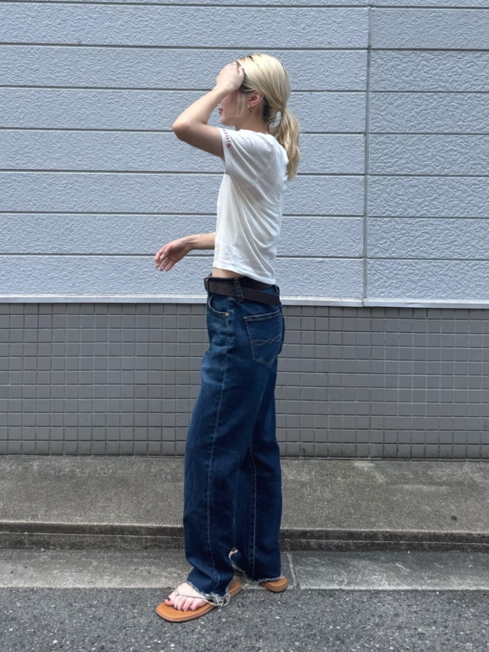 シルバー系のサンダル、ブルー系のデニムパンツ、ホワイト系のTシャツ/カットソーを着用したレディースの夏コーディネートの2枚目の写真