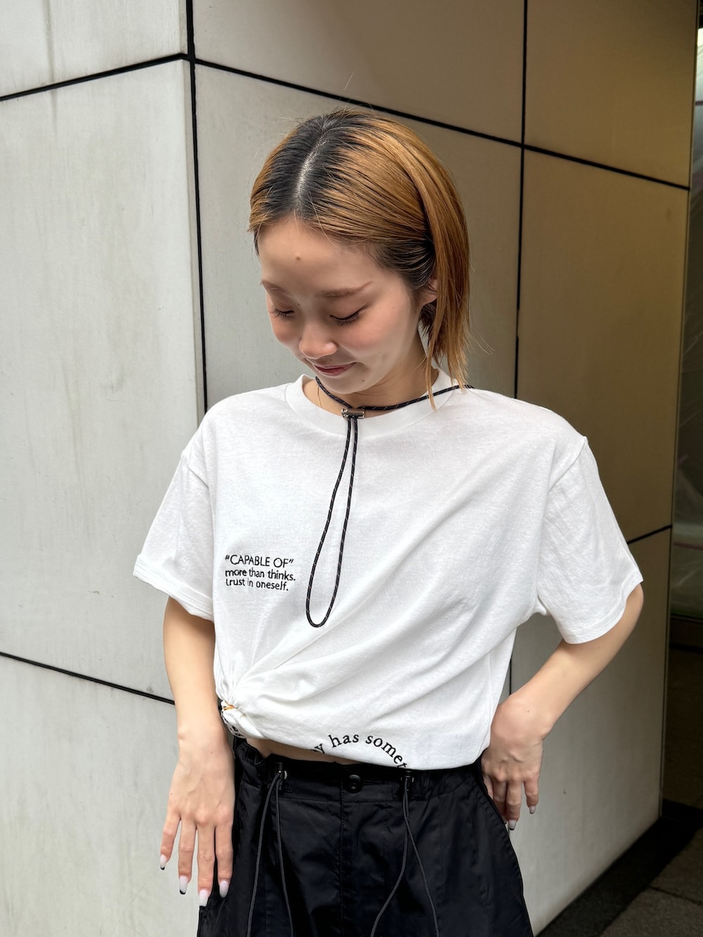 ホワイト系のTシャツ/カットソー、ブラック系のカーゴパンツ、ブラック系のサンダルを着用したレディースの夏コーディネートの4枚目の写真