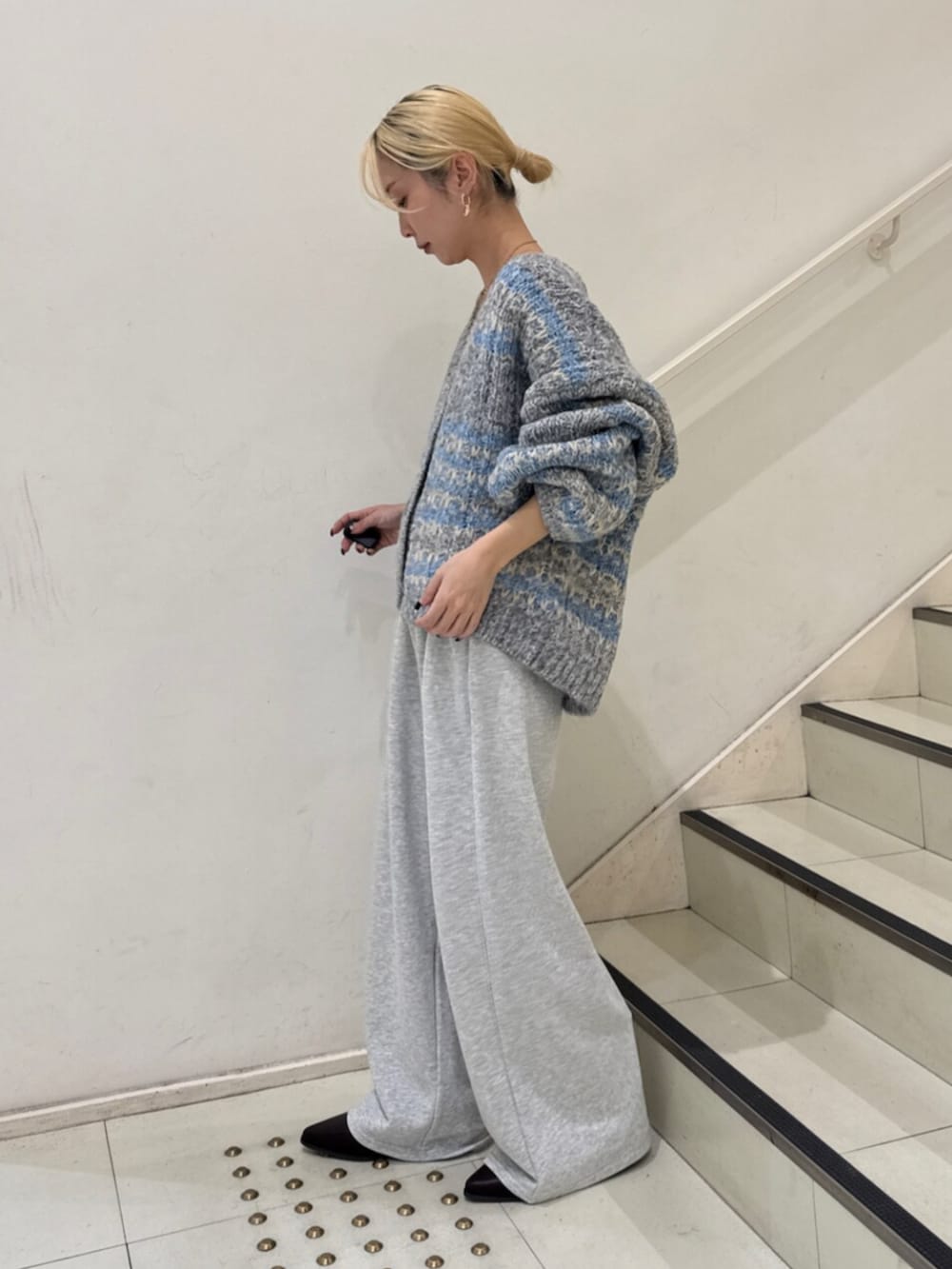 ブラウン系のブーツ、グレー系のスウェットパンツ、ブルー系のカーディガン/ボレロを着用したレディースの冬コーディネートの2枚目の写真