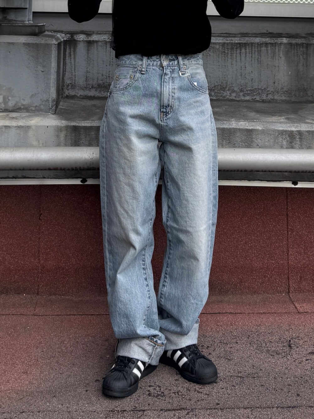 ブラック系のTシャツ/カットソー、ブルー系のデニムパンツを着用したレディースの冬コーディネートの5枚目の写真