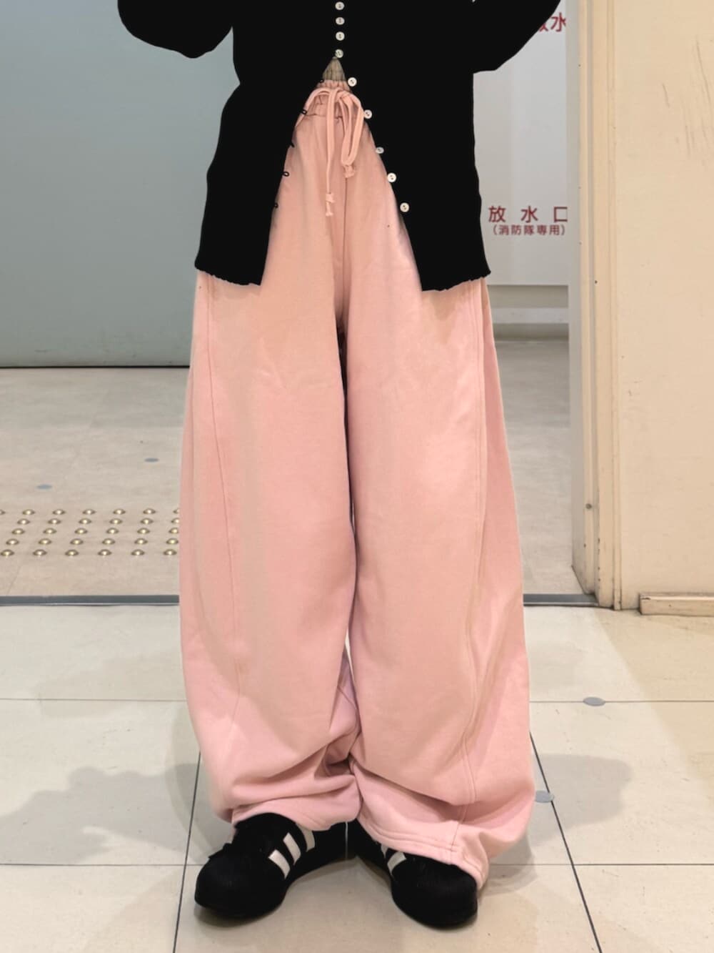 ブラック系のカーディガン/ボレロ、ピンク系のスウェットパンツを着用したレディースの冬コーディネートの5枚目の写真