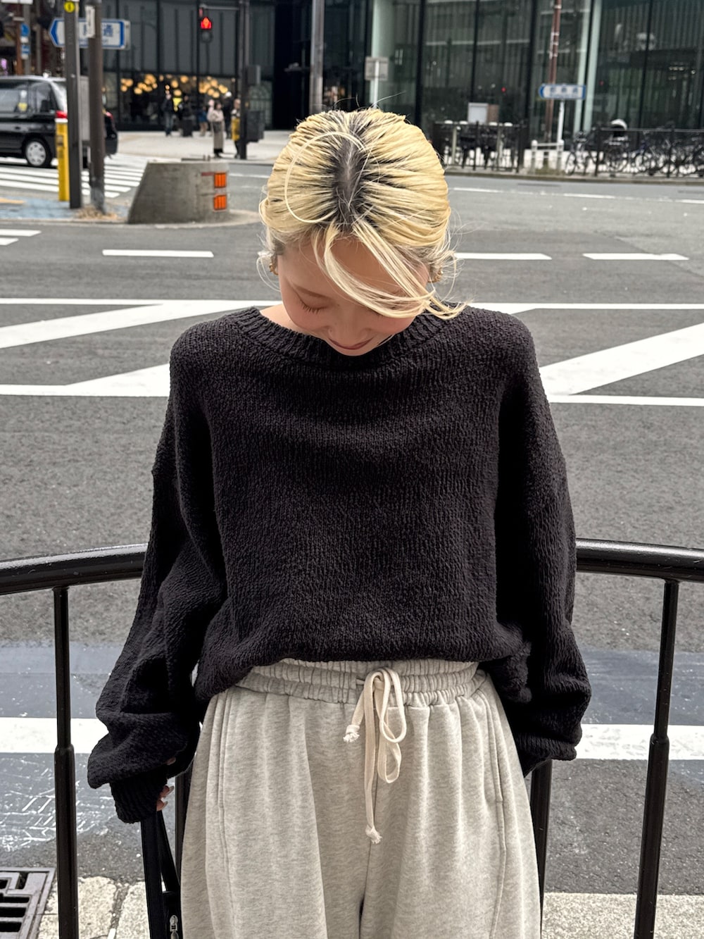 グレー系のニット/セーター、ホワイト系のスウェットパンツ、ブラック系のスニーカーを着用したレディースの冬コーディネートの4枚目の写真