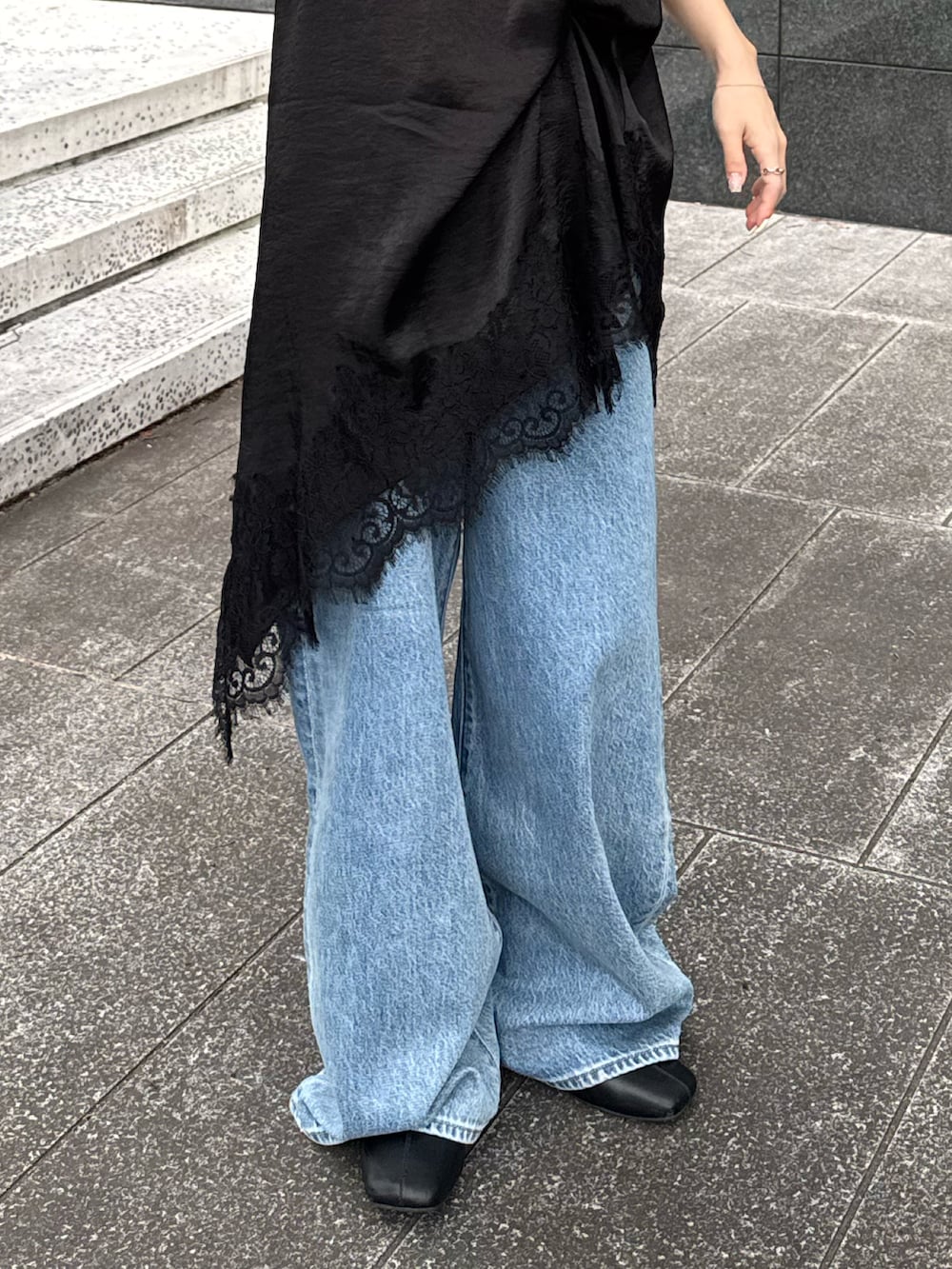 ブラック系のワンピース、ブルー系のデニムパンツ、ブラック系のサンダルを着用したレディースの夏コーディネートの5枚目の写真
