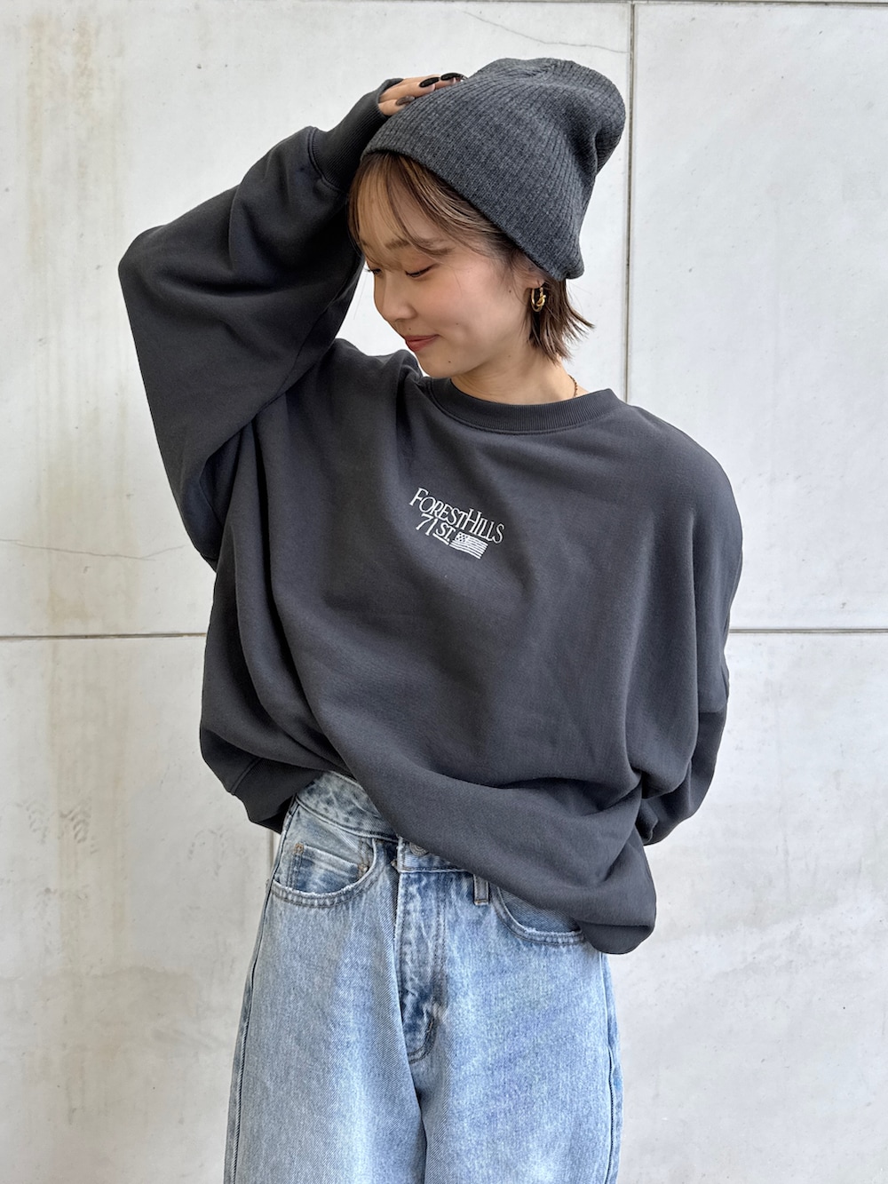 グレー系のスウェット、ブルー系のデニムパンツ、グレー系のニットキャップ/ビーニーを着用したレディースの冬コーディネートの7枚目の写真