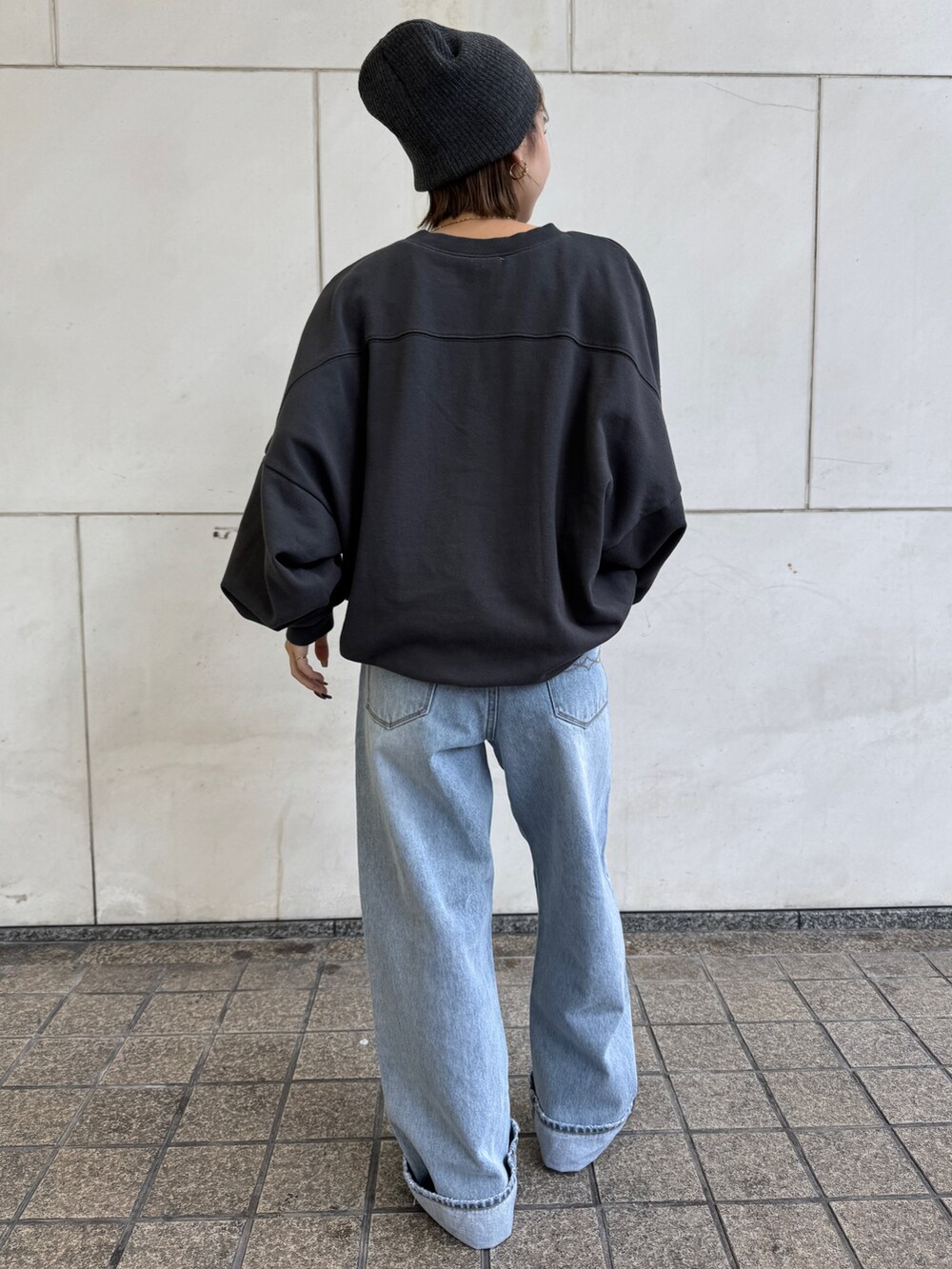 グレー系のスウェット、ブルー系のデニムパンツ、グレー系のニットキャップ/ビーニーを着用したレディースの冬コーディネートの4枚目の写真