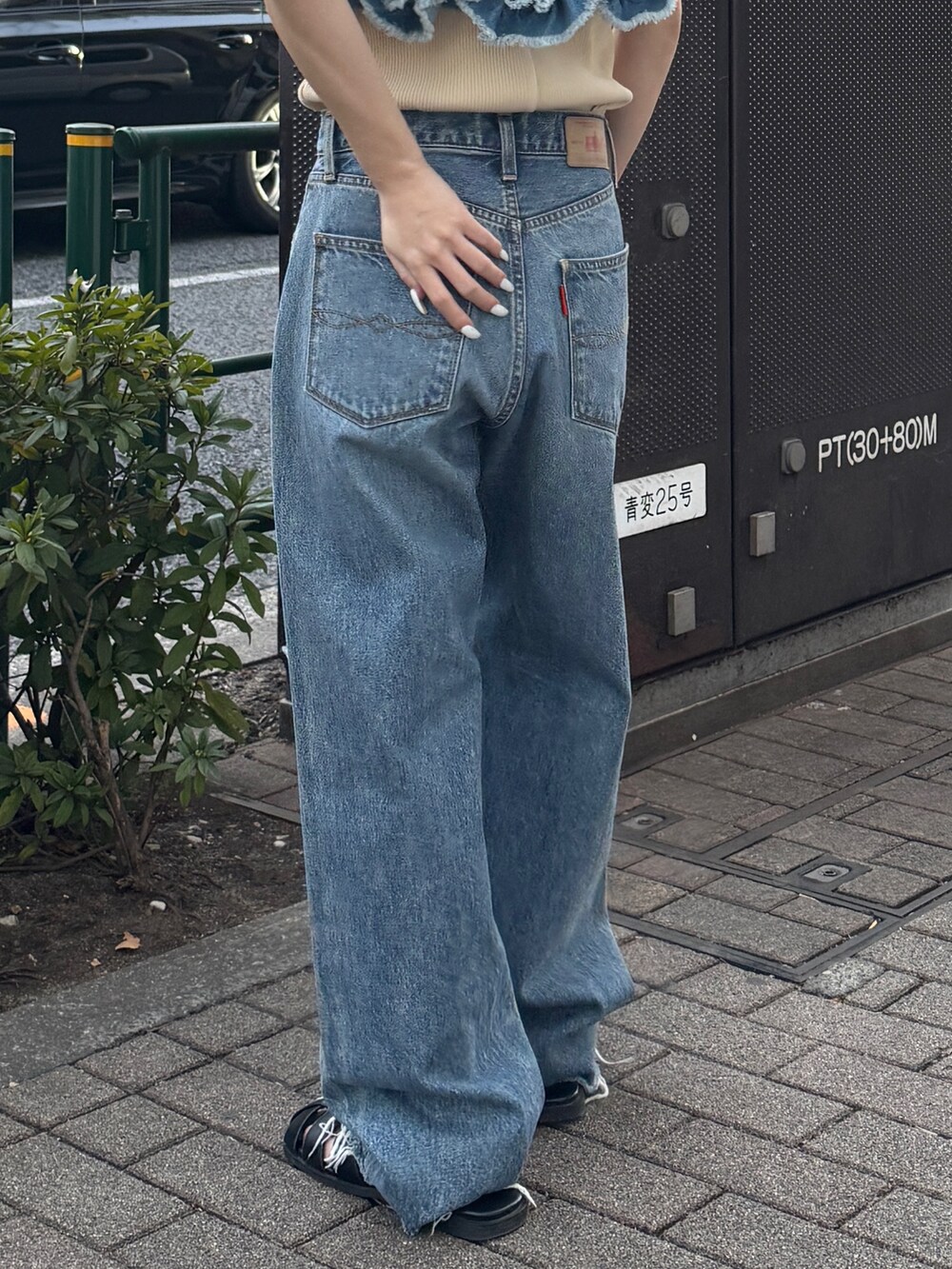 ブルー系のキャミソール、ホワイト系のタンクトップ、ブルー系のデニムパンツを着用したレディースの春コーディネートの7枚目の写真