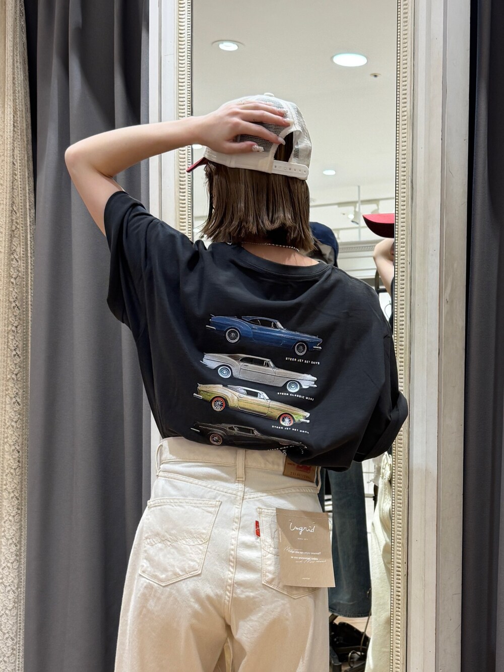 グレー系のTシャツ/カットソー、ホワイト系のデニムパンツ、ブラック系のサンダルを着用したレディースの春コーディネートの6枚目の写真