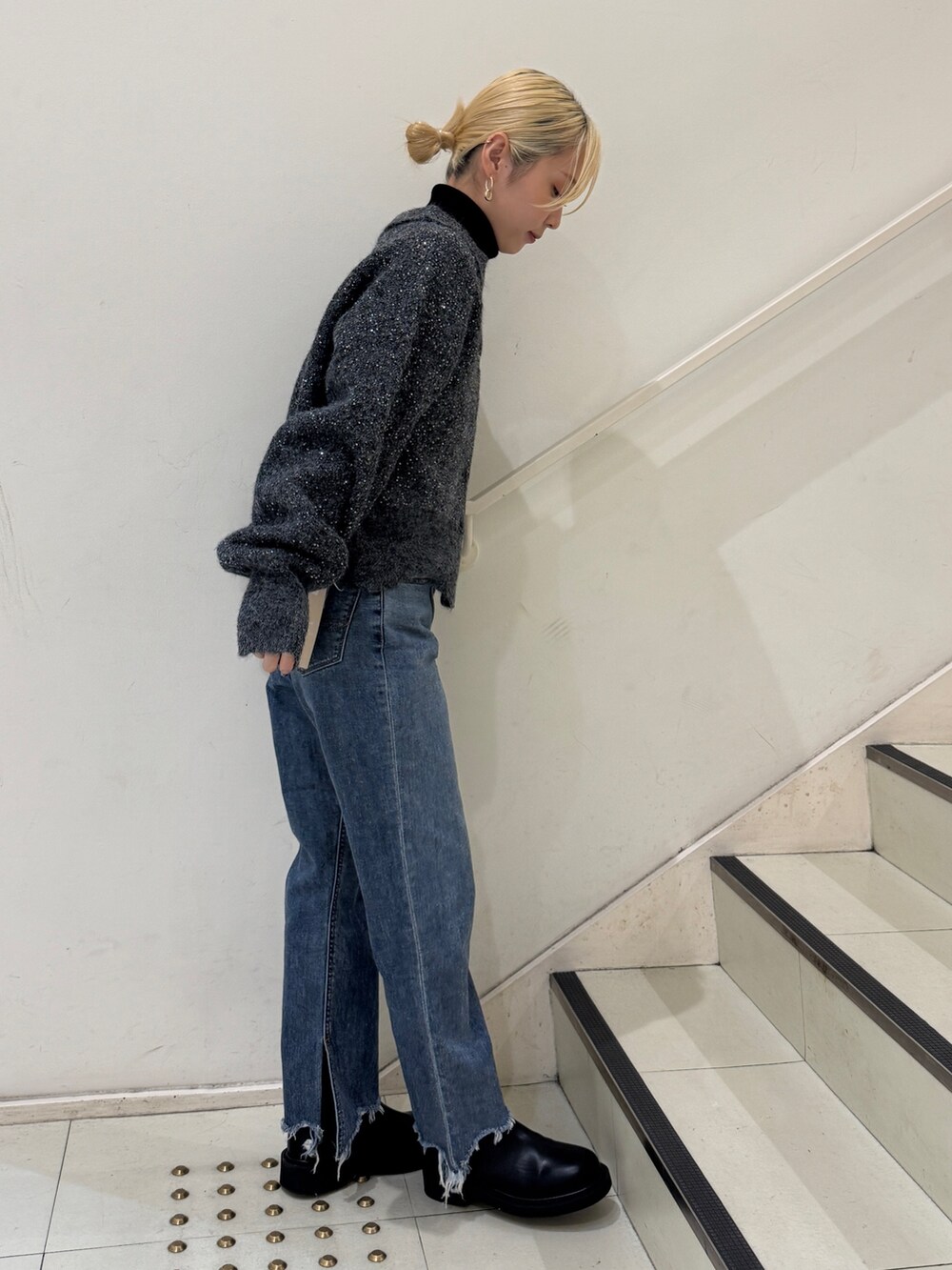 グレー系のカーディガン/ボレロ、ブラック系のニット/セーター、ブルー系のデニムパンツを着用したレディースの冬コーディネートの2枚目の写真