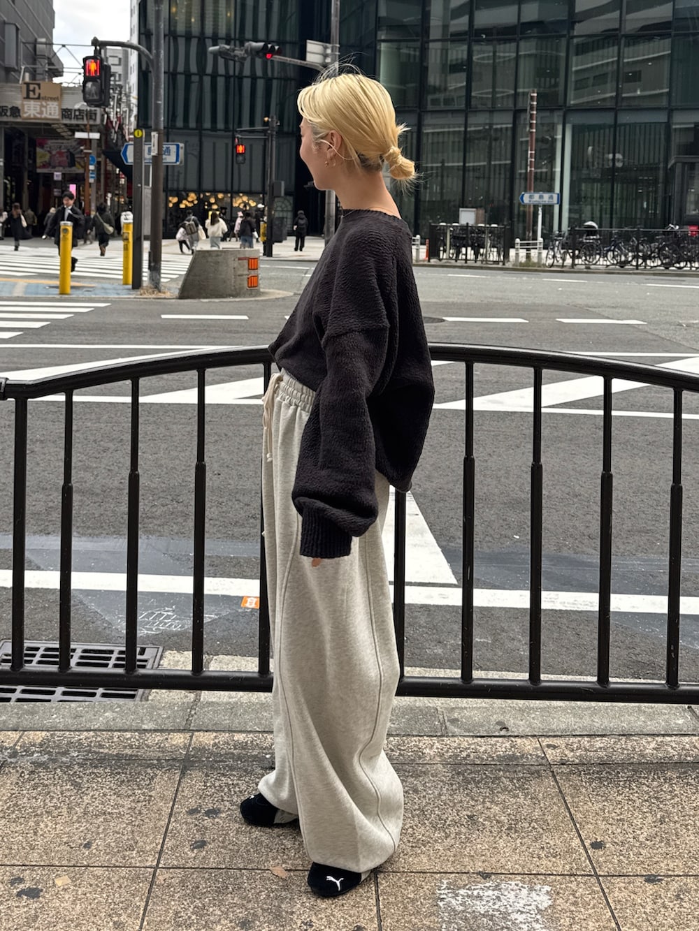 グレー系のニット/セーター、ホワイト系のスウェットパンツ、ブラック系のスニーカーを着用したレディースの冬コーディネートの2枚目の写真