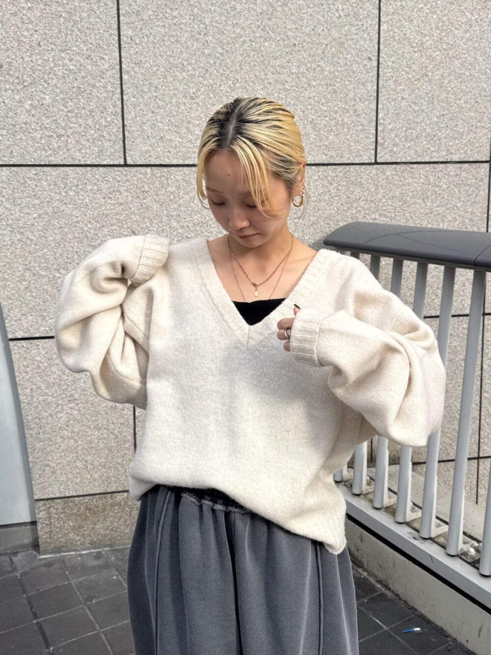 グレー系のスウェットパンツ、ホワイト系のニット/セーターを着用したレディースの秋コーディネートの4枚目の写真