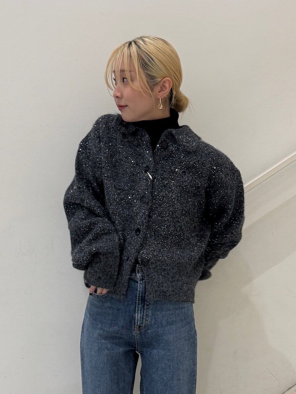 グレー系のカーディガン/ボレロ、ブラック系のニット/セーター、ブルー系のデニムパンツを着用したレディースの冬コーディネートの4枚目の写真