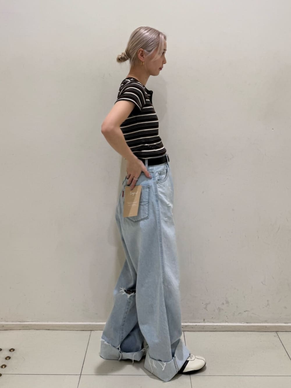 ブルー系のデニムパンツ、ブラウン系のTシャツ/カットソーを着用したレディースの春コーディネートの2枚目の写真