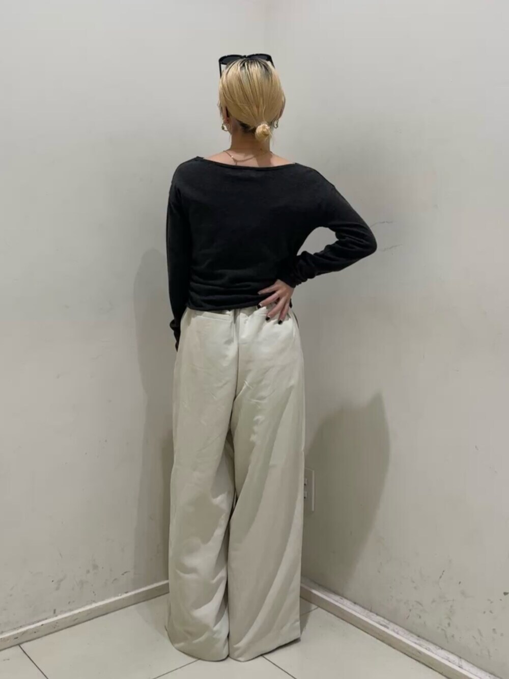 ホワイト系のその他パンツ、グレー系のニット/セーター、ブラック系のメガネを着用したレディースの冬コーディネートの3枚目の写真