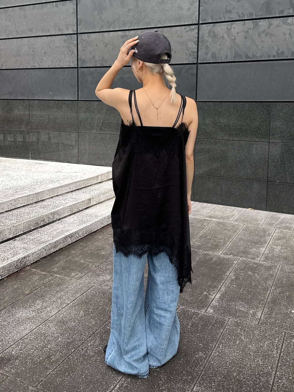 ブラック系のワンピース、ブルー系のデニムパンツ、ブラック系のサンダルを着用したレディースの夏コーディネートの3枚目の写真