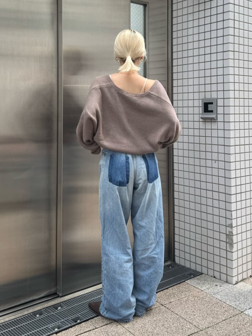 ブラウン系のブーツ、ブルー系のデニムパンツ、ベージュ系のニット/セーターを着用したレディースの秋コーディネートの3枚目の写真