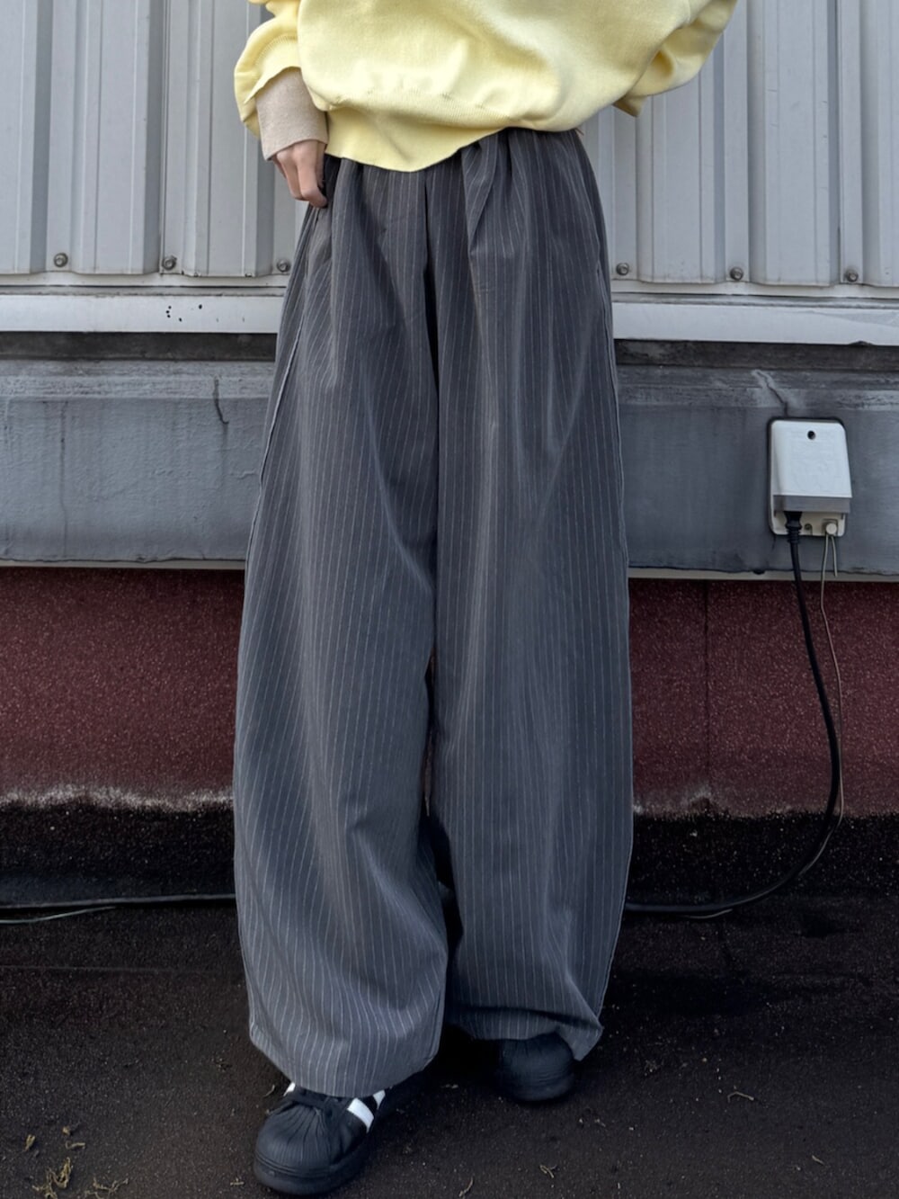 グレー系のその他パンツ、イエロー系のニット/セーターを着用したレディースの冬コーディネートの5枚目の写真