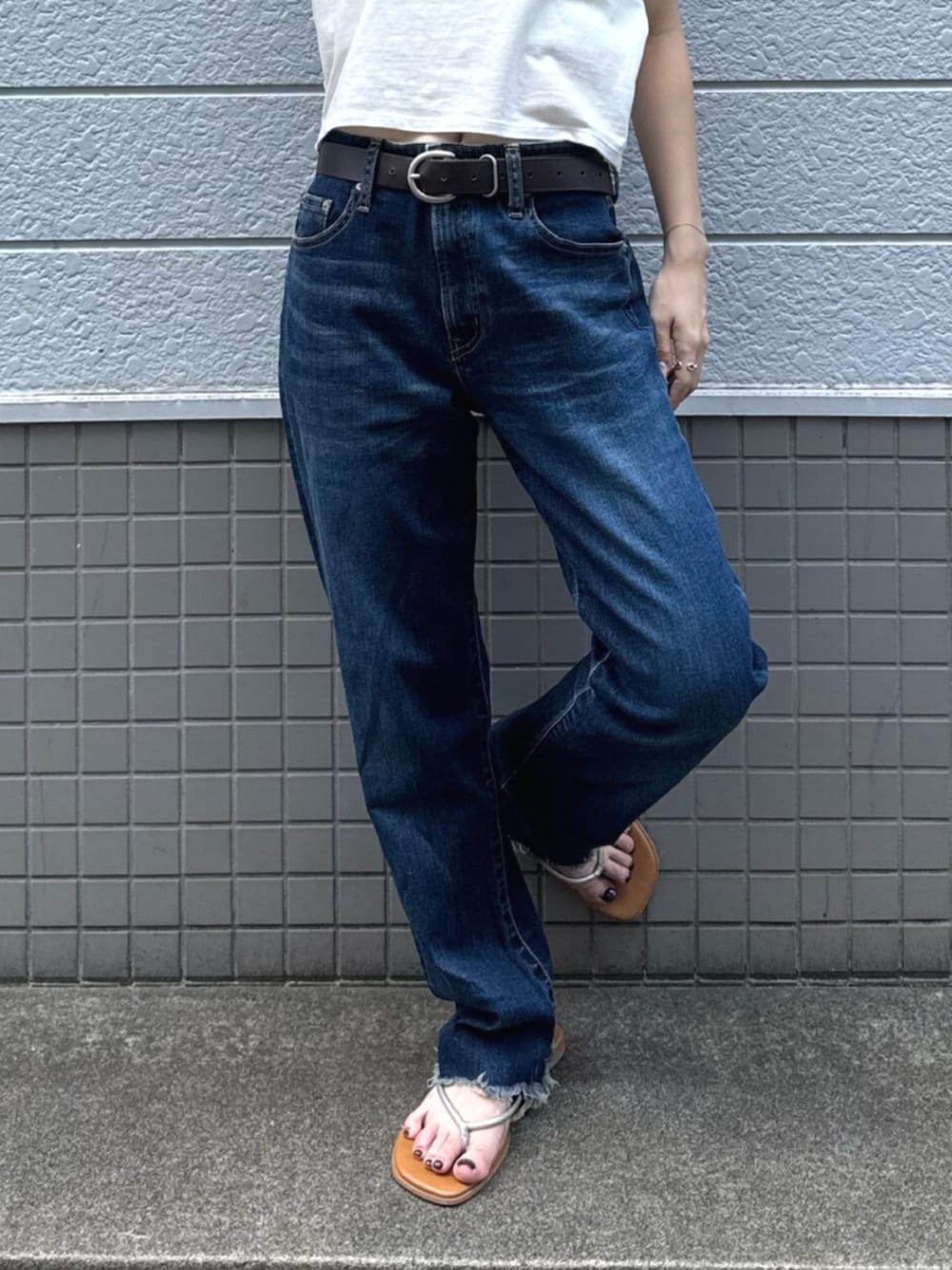 シルバー系のサンダル、ブルー系のデニムパンツ、ホワイト系のTシャツ/カットソーを着用したレディースの夏コーディネートの5枚目の写真