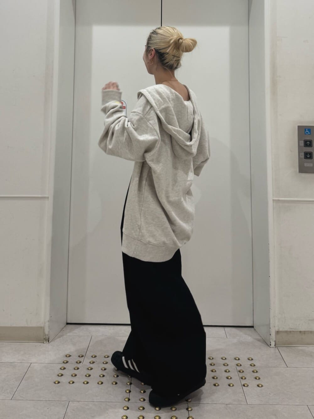 ホワイト系のパーカー、ブラック系のその他パンツ、ブラック系のキャミソールを着用したレディースの春コーディネートの2枚目の写真