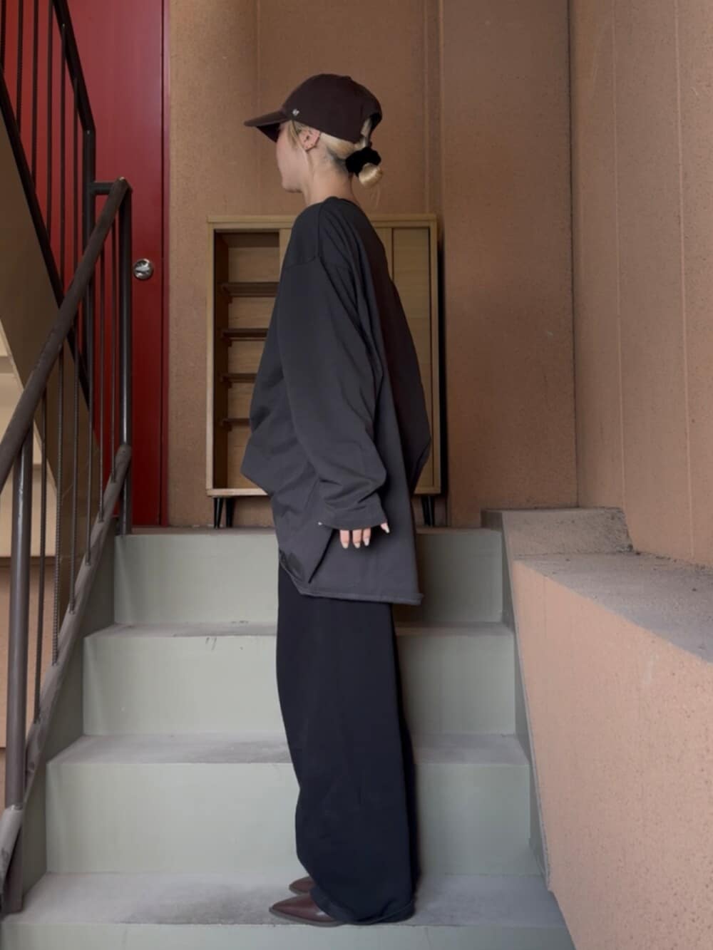 ブラウン系のブーツ、グレー系のTシャツ/カットソー、ブラック系のキャミソールを着用したレディースの春コーディネートの2枚目の写真