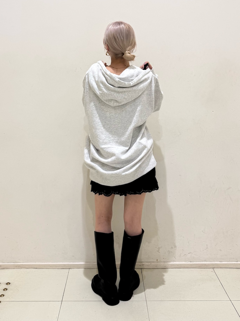 グレー系のパーカー、ブラック系のその他パンツ、ブラック系のブーツを着用したレディースの春コーディネートの3枚目の写真