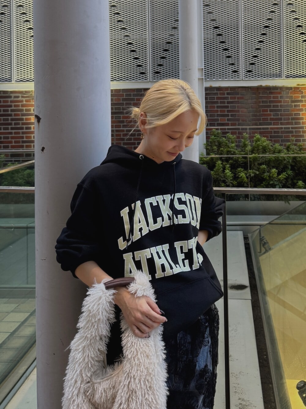 ブラック系のパーカー、ブラック系のスカート、ブルー系のデニムパンツを着用したレディースの秋コーディネートの5枚目の写真