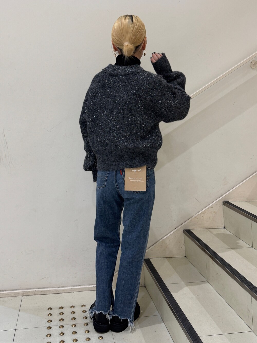 グレー系のカーディガン/ボレロ、ブラック系のニット/セーター、ブルー系のデニムパンツを着用したレディースの冬コーディネートの3枚目の写真