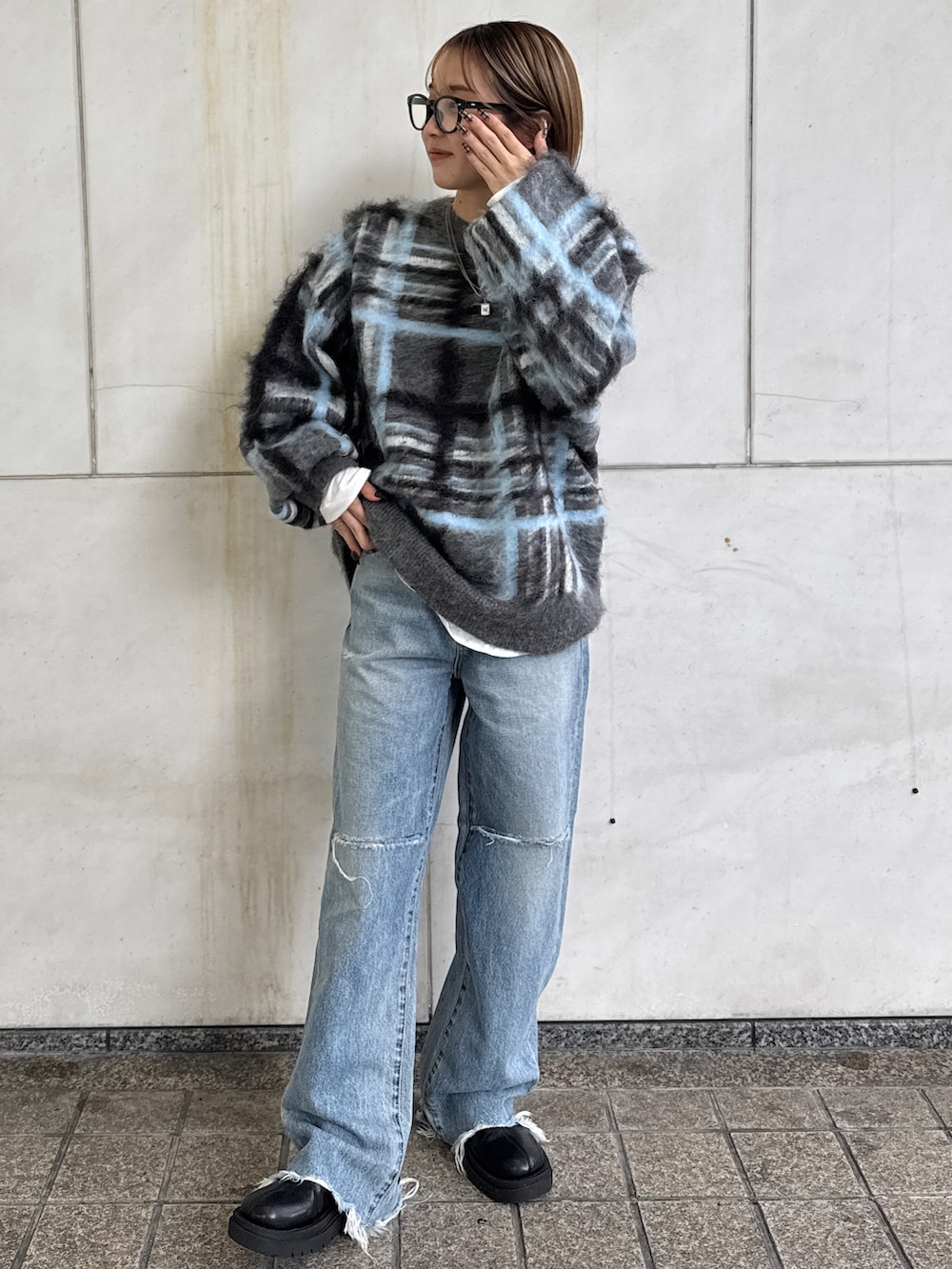 グレー系のニット/セーター、ホワイト系のTシャツ/カットソー、ブルー系のデニムパンツを着用したレディースの秋コーディネートの2枚目の写真