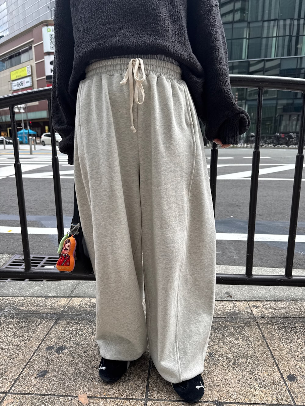 グレー系のニット/セーター、ホワイト系のスウェットパンツ、ブラック系のスニーカーを着用したレディースの冬コーディネートの5枚目の写真