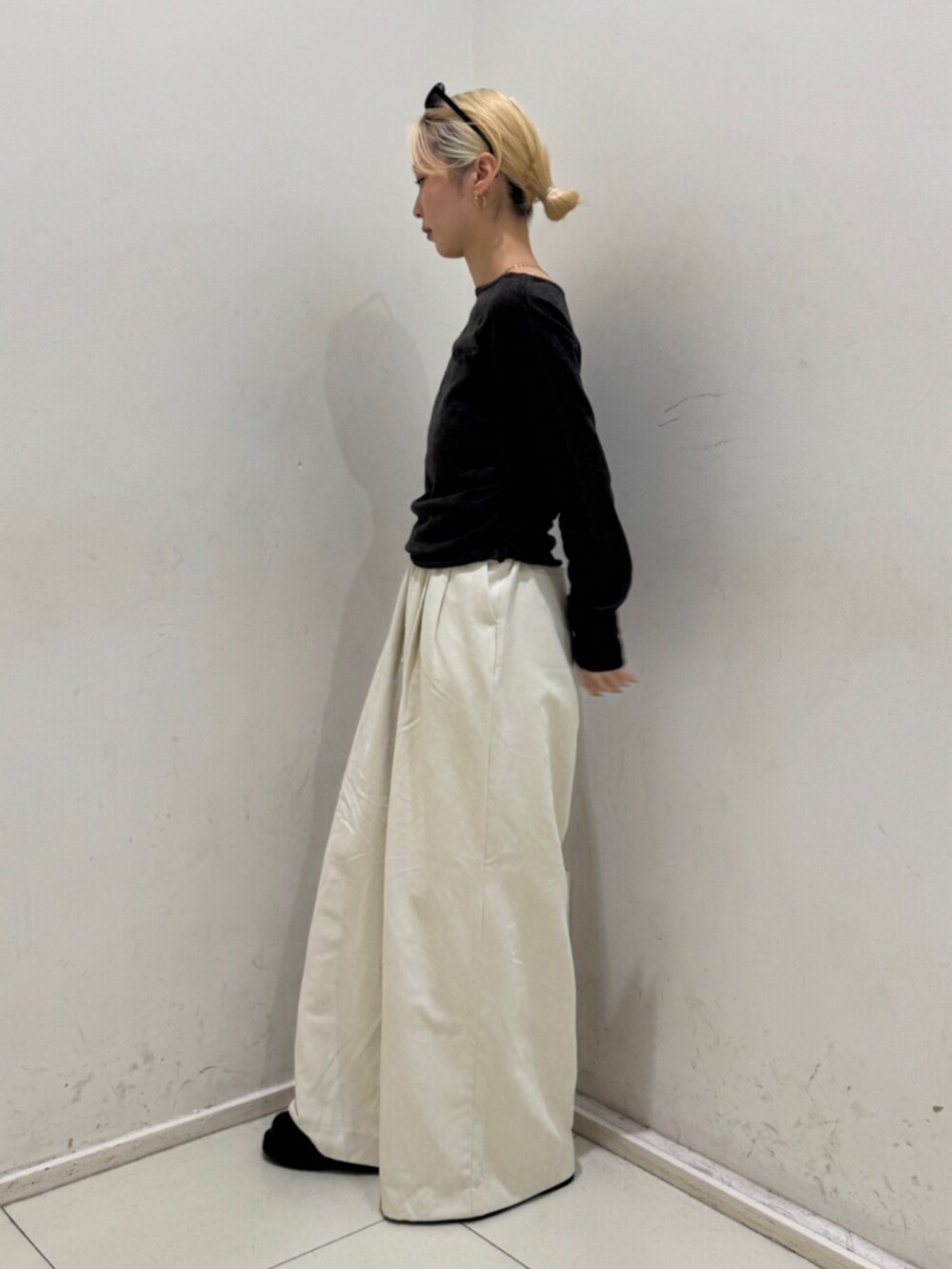 ホワイト系のその他パンツ、グレー系のニット/セーター、ブラック系のメガネを着用したレディースの冬コーディネートの2枚目の写真