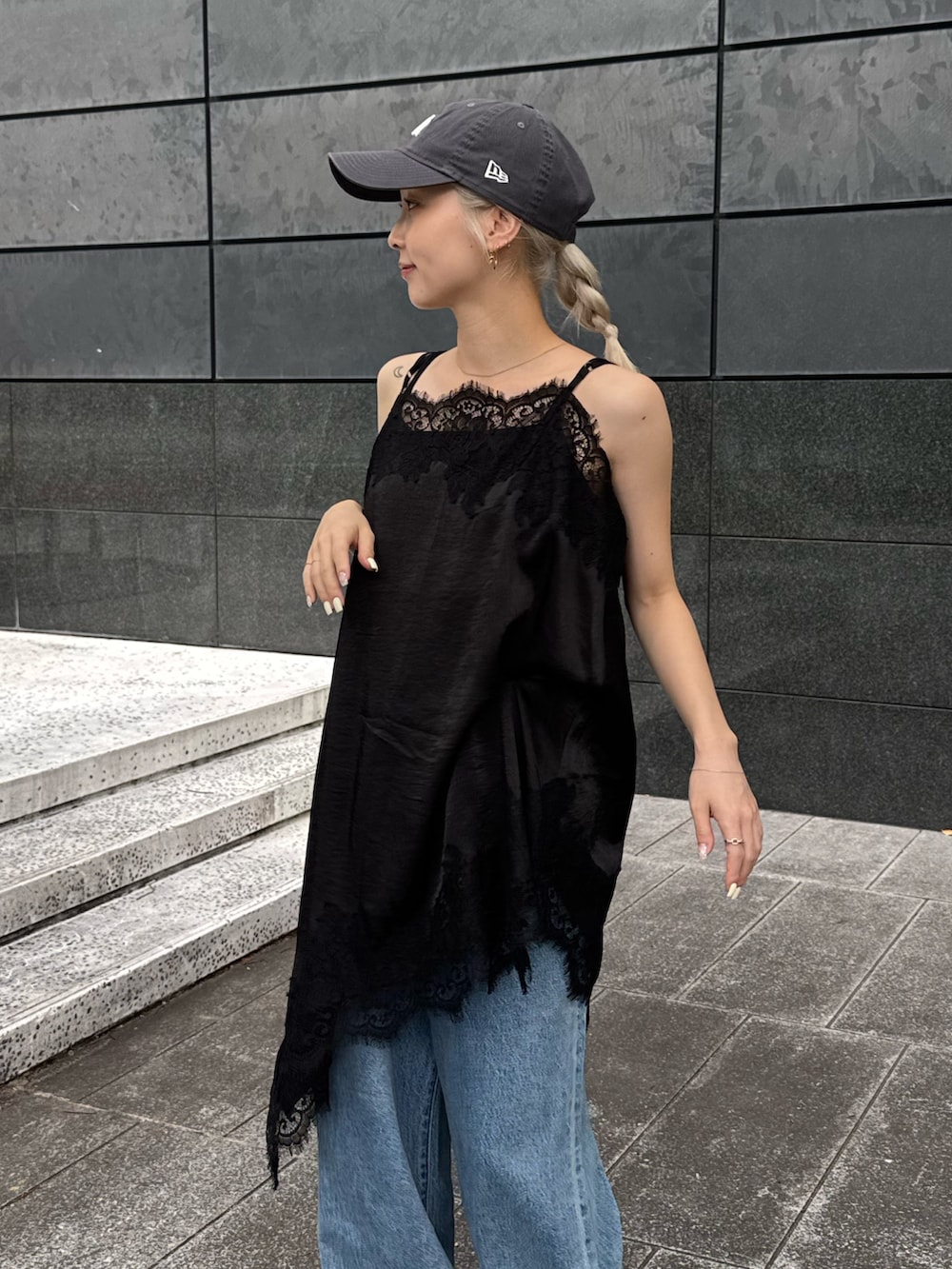 ブラック系のワンピース、ブルー系のデニムパンツ、ブラック系のサンダルを着用したレディースの夏コーディネートの4枚目の写真