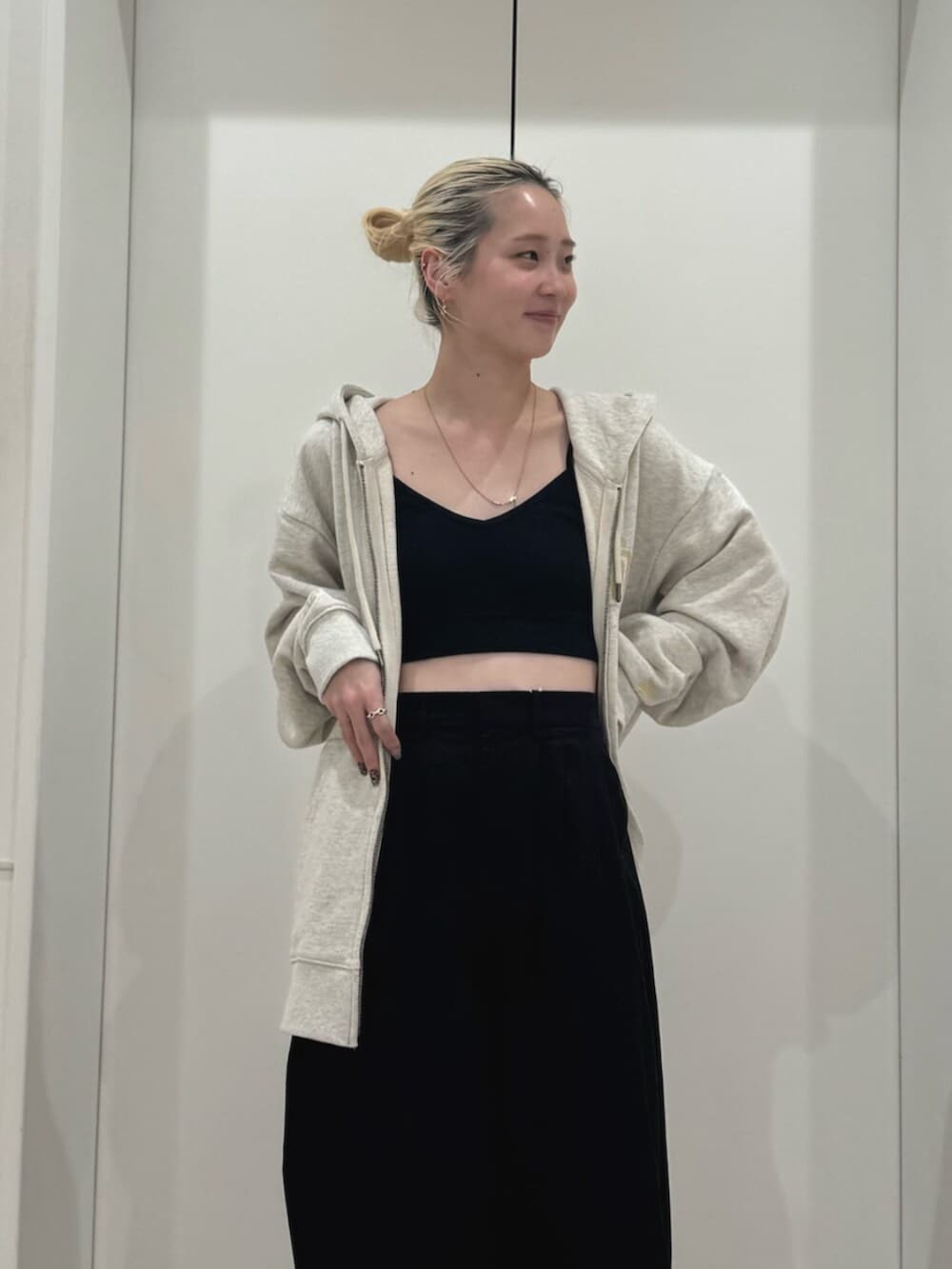 ホワイト系のパーカー、ブラック系のその他パンツ、ブラック系のキャミソールを着用したレディースの春コーディネートの4枚目の写真