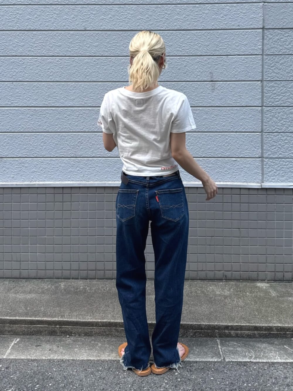 シルバー系のサンダル、ブルー系のデニムパンツ、ホワイト系のTシャツ/カットソーを着用したレディースの夏コーディネートの3枚目の写真