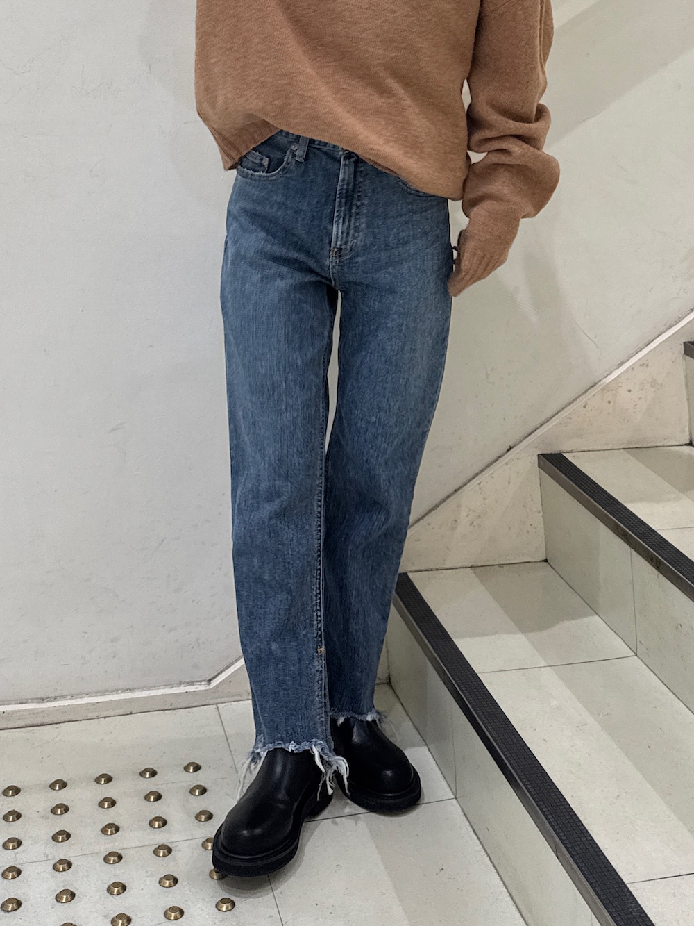 イエロー系のニット/セーター、ブラック系のニット/セーター、ブルー系のデニムパンツを着用したレディースの冬コーディネートの5枚目の写真