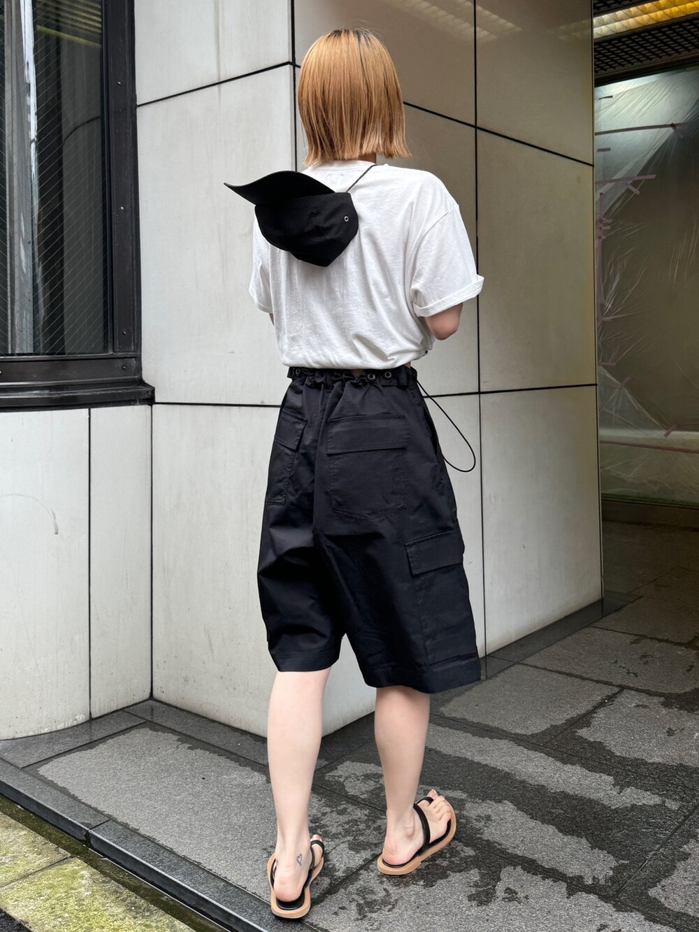 ホワイト系のTシャツ/カットソー、ブラック系のカーゴパンツ、ブラック系のサンダルを着用したレディースの夏コーディネートの3枚目の写真