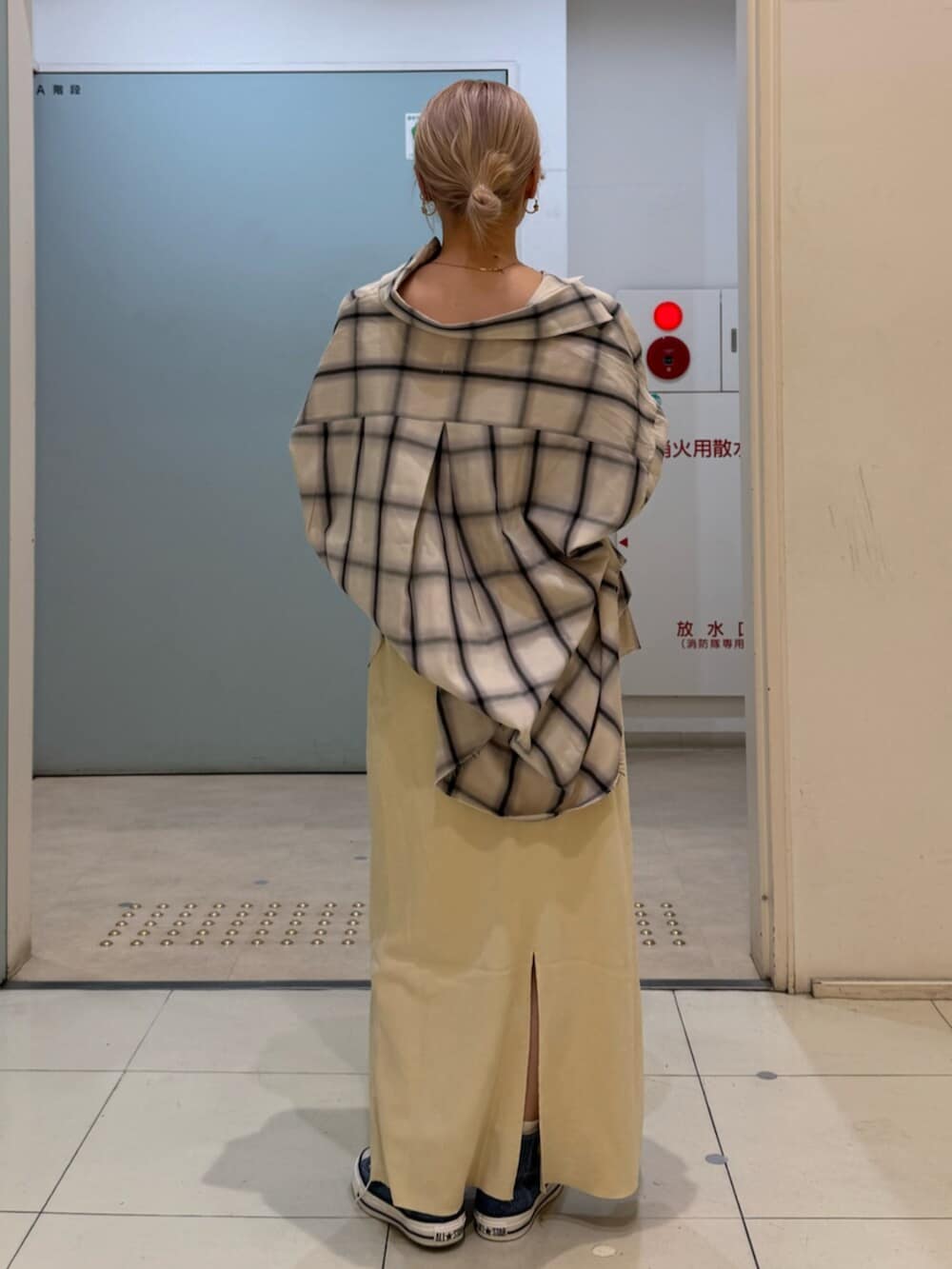 イエロー系のスカート、ブルー系のスニーカー、ホワイト系のシャツ/ブラウスを着用したレディースの冬コーディネートの3枚目の写真