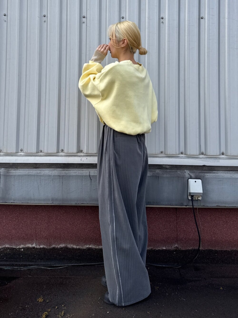 グレー系のその他パンツ、イエロー系のニット/セーターを着用したレディースの冬コーディネートの2枚目の写真