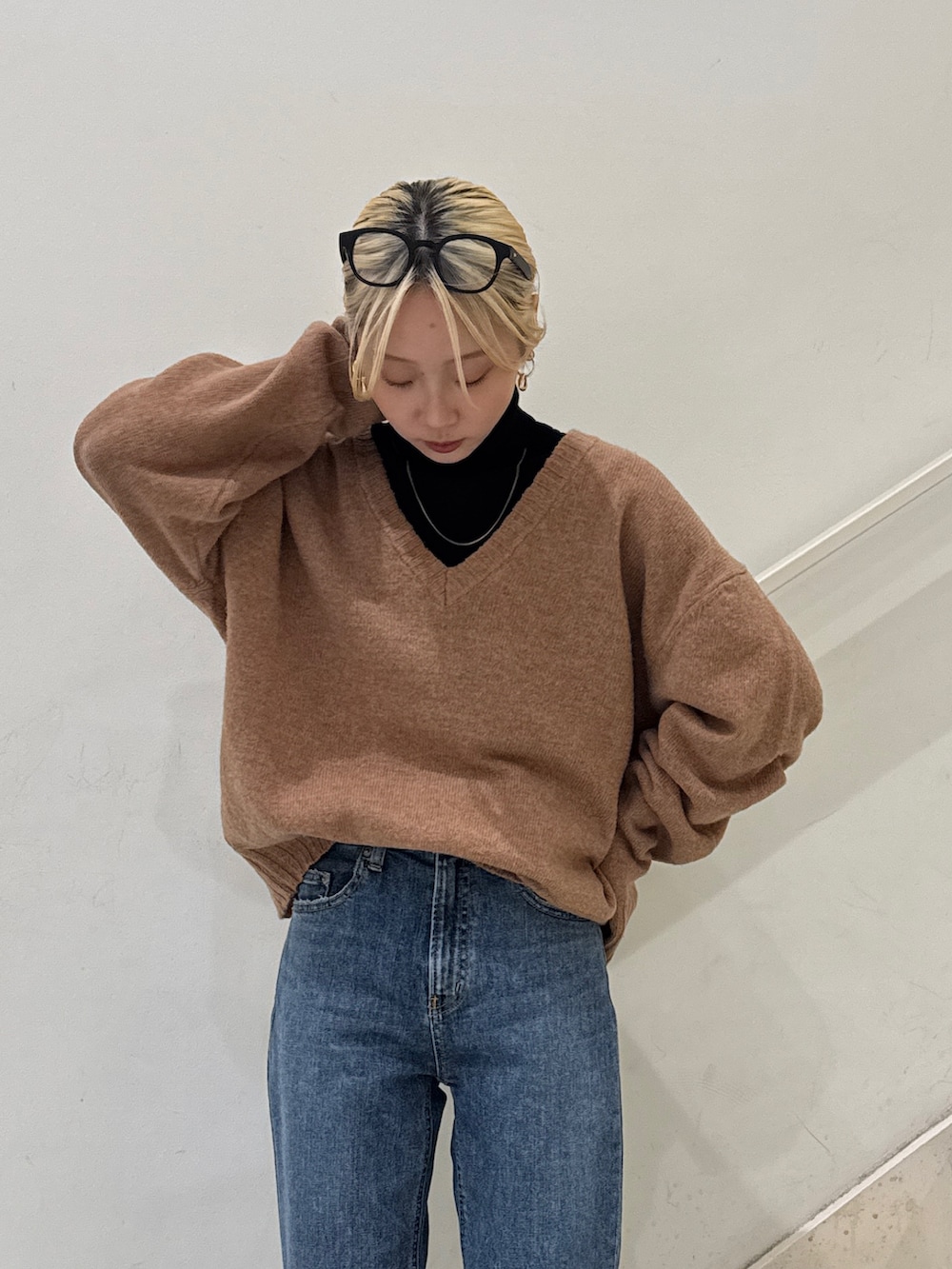 イエロー系のニット/セーター、ブラック系のニット/セーター、ブルー系のデニムパンツを着用したレディースの冬コーディネートの4枚目の写真