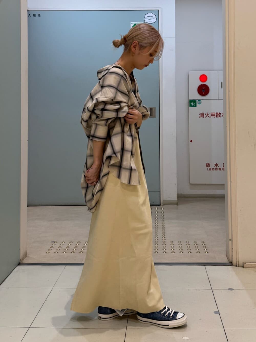 イエロー系のスカート、ブルー系のスニーカー、ホワイト系のシャツ/ブラウスを着用したレディースの冬コーディネートの2枚目の写真