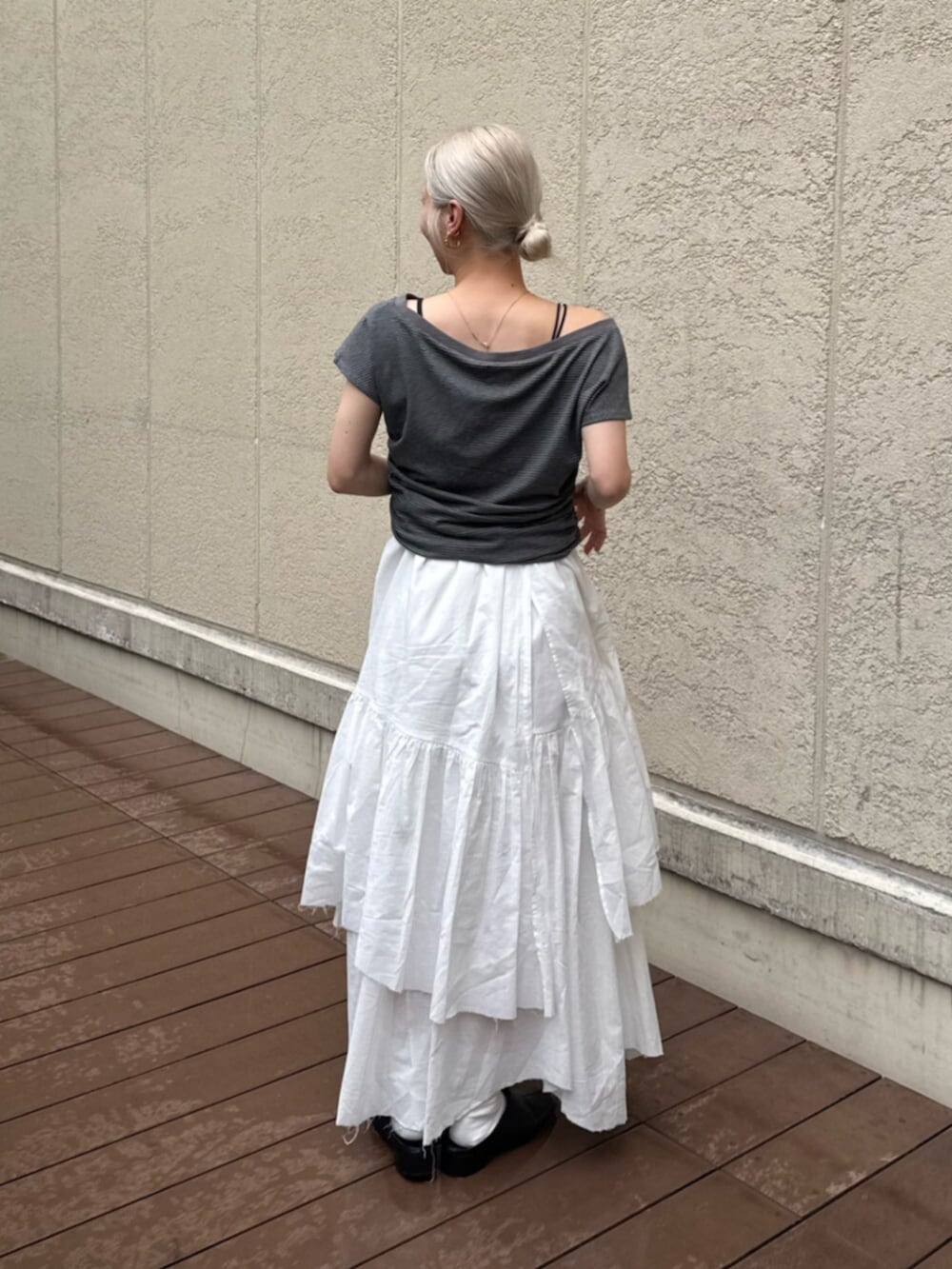 ブラック系のサンダル、グレー系のTシャツ/カットソー、ホワイト系のスカートを着用したレディースの夏コーディネートの3枚目の写真
