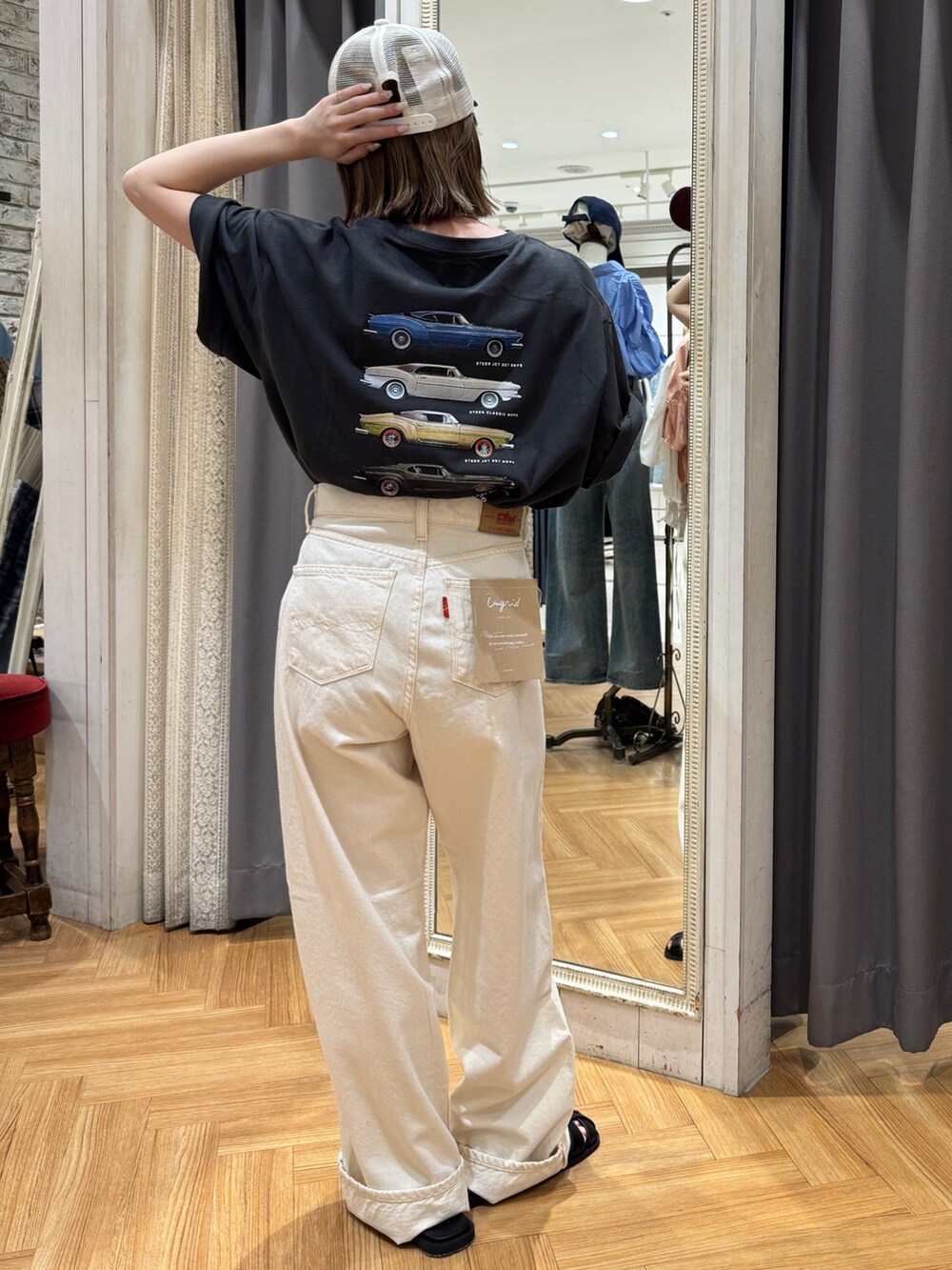 グレー系のTシャツ/カットソー、ホワイト系のデニムパンツ、ブラック系のサンダルを着用したレディースの春コーディネートの3枚目の写真
