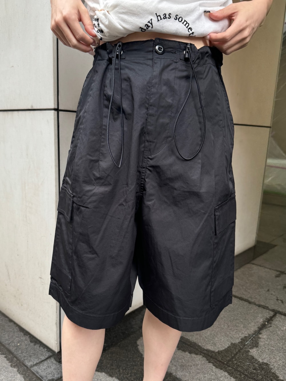ホワイト系のTシャツ/カットソー、ブラック系のカーゴパンツ、ブラック系のサンダルを着用したレディースの夏コーディネートの5枚目の写真