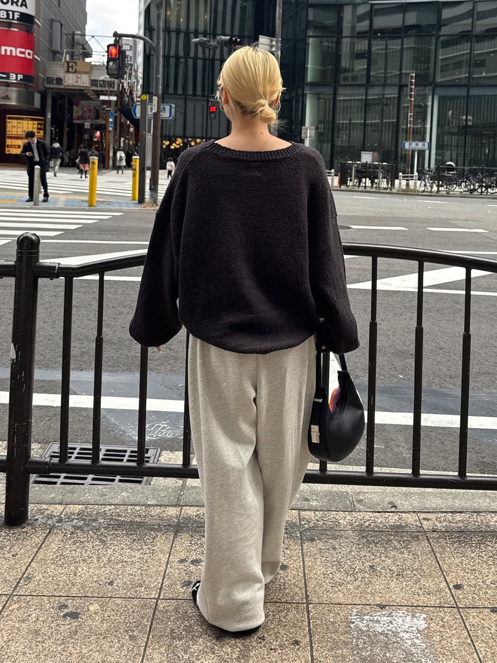 グレー系のニット/セーター、ホワイト系のスウェットパンツ、ブラック系のスニーカーを着用したレディースの冬コーディネートの3枚目の写真