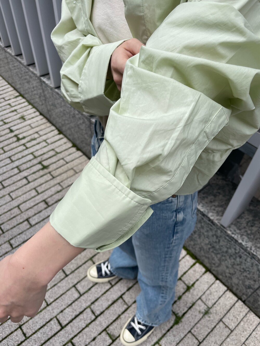 グリーン系のシャツ/ブラウス、ホワイト系のキャミソール、ブルー系のデニムパンツを着用したレディースの春コーディネートの8枚目の写真