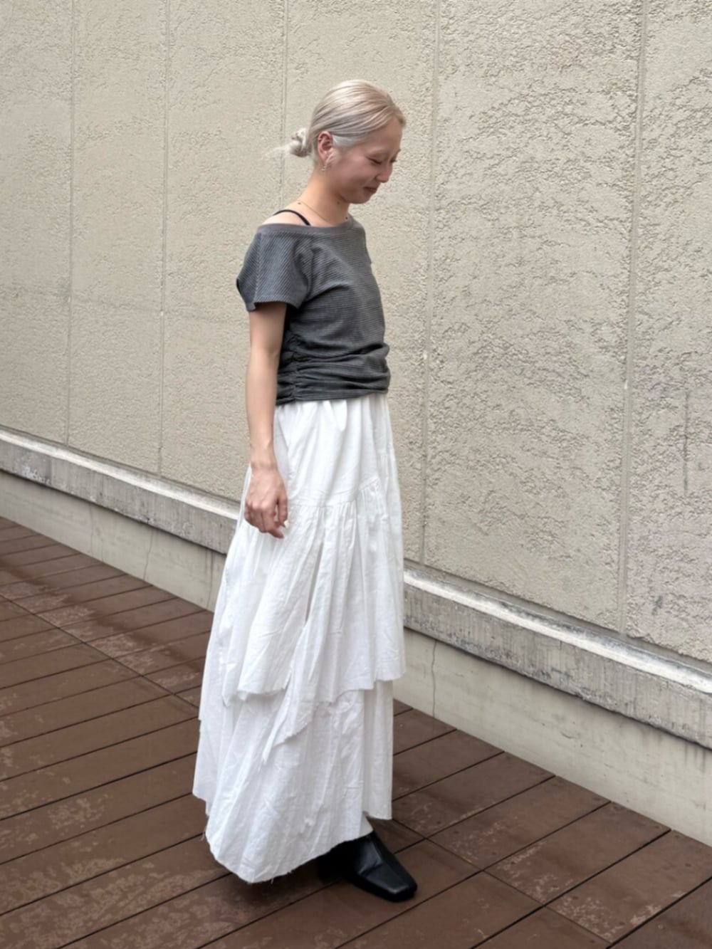 ブラック系のサンダル、グレー系のTシャツ/カットソー、ホワイト系のスカートを着用したレディースの夏コーディネートの2枚目の写真