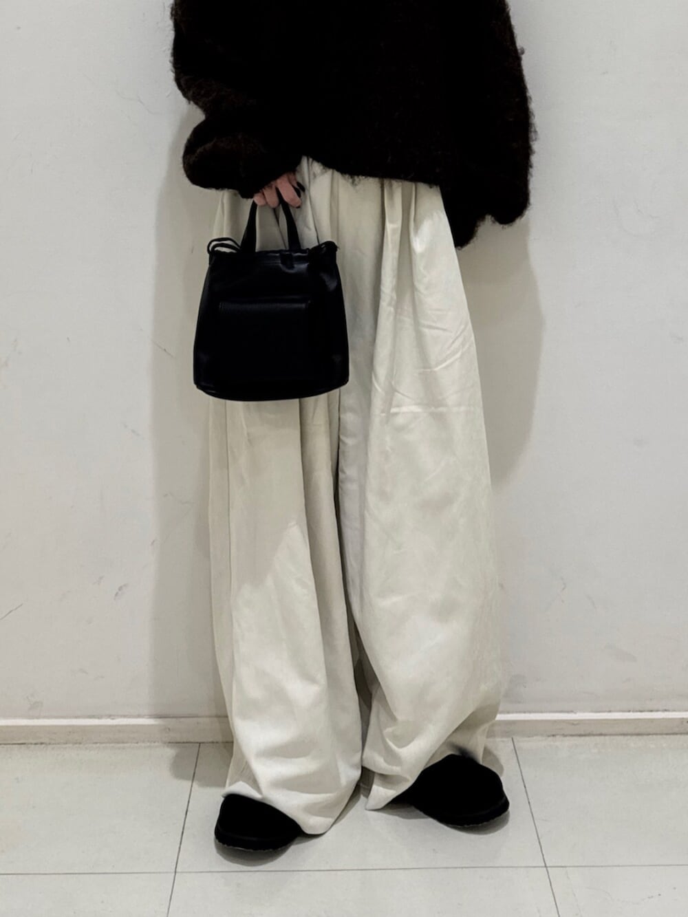 ブラック系のショルダーバッグ、ホワイト系のその他パンツ、ブラック系のスリッポンを着用したレディースの秋コーディネートの5枚目の写真