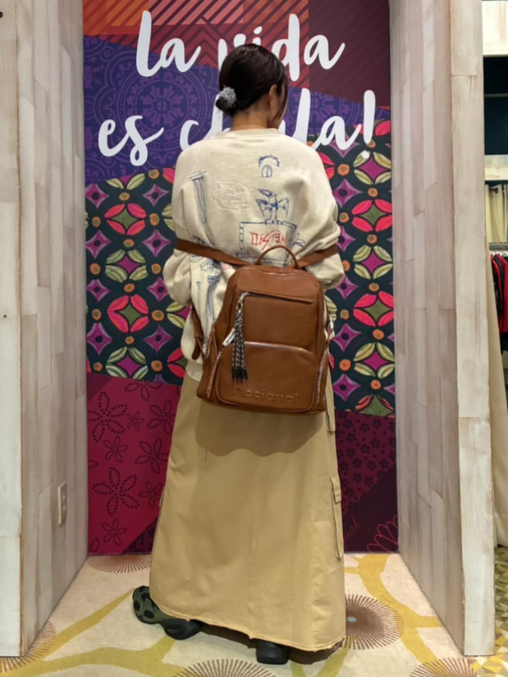 ホワイト系のスウェット、ブラウン系のスカート、ブラウン系のバックパック/リュックを着用したレディースの秋コーディネートの2枚目の写真